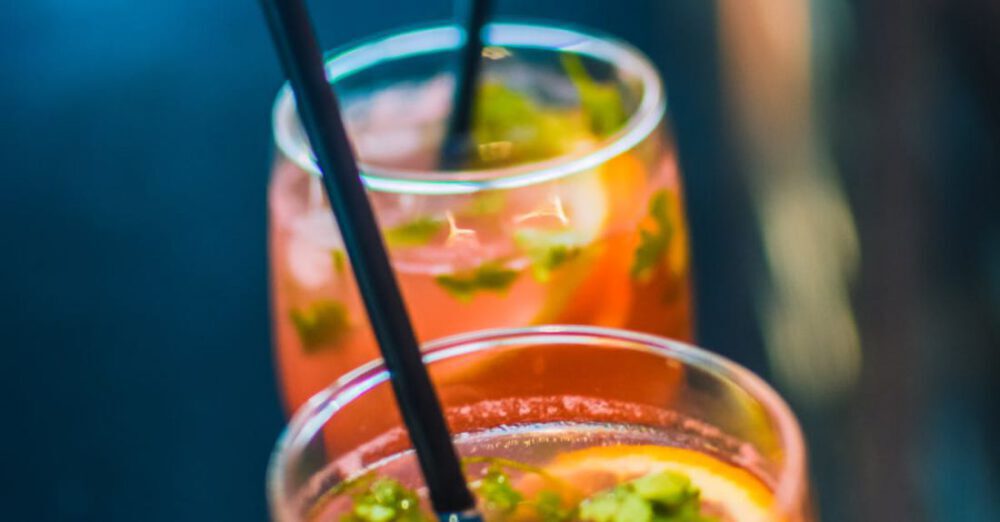 Beverages - Two Beverages In Footed Glasses With Black Straws